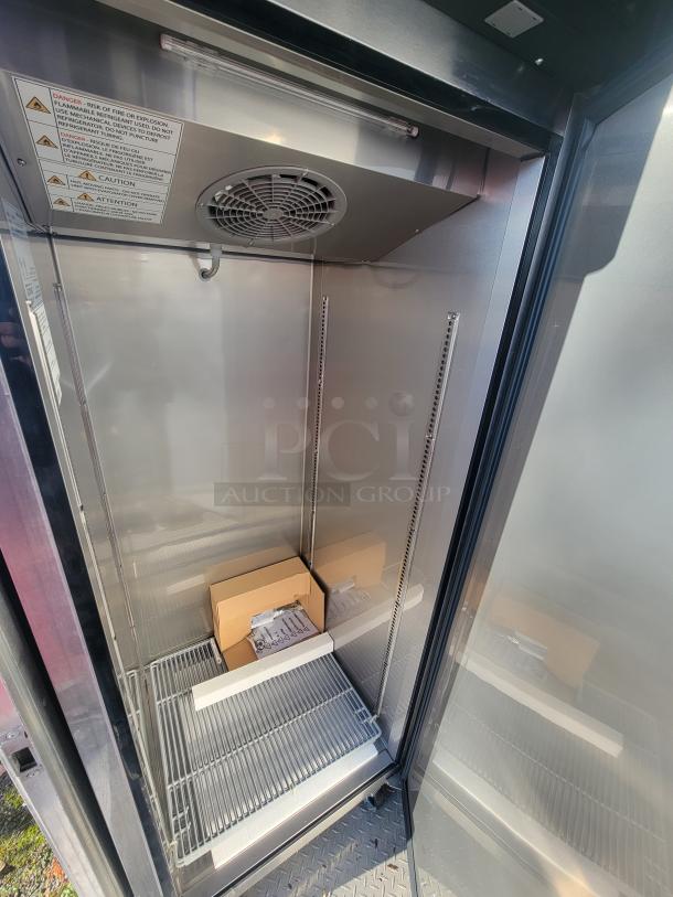 Inside view of new Titanium 28' food trailer, 2021 model. Pristine stainless-steel interior with unused shelving and equipment.