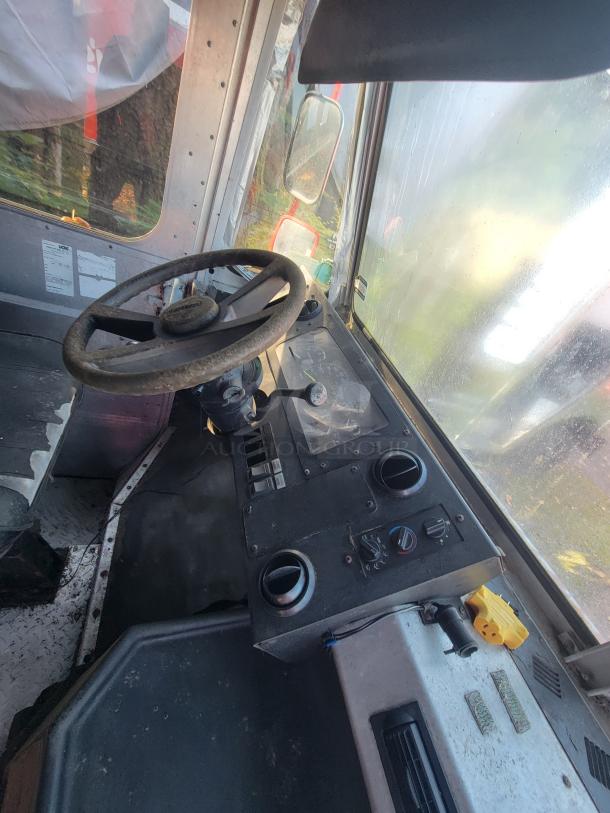 Interior view of 2003 Chevrolet P24 Workhorse food truck. Features include a functional dashboard, steering wheel, and control switches in used condition.