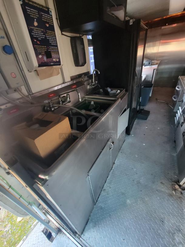2003 Workhorse food truck with commercial kitchen, stainless steel sinks, storage, and appliances, on Chevrolet P24 chassis.