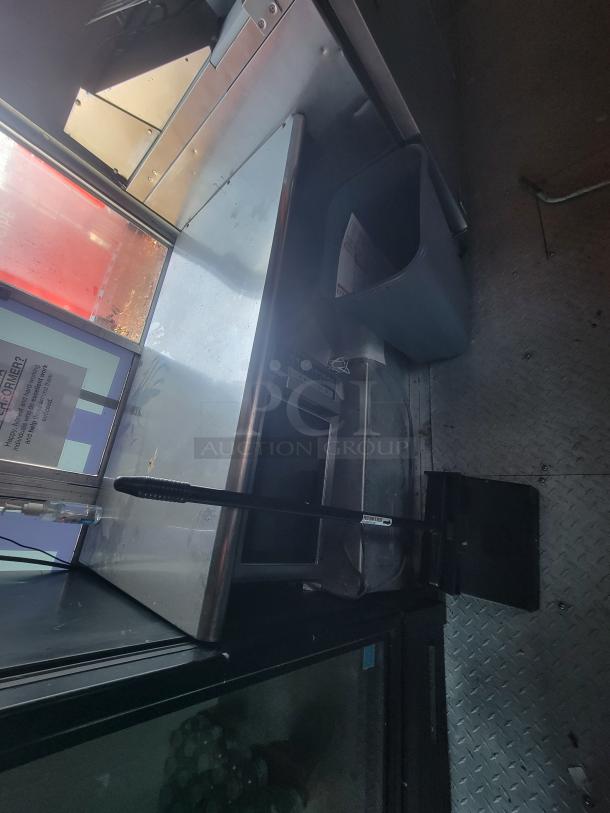 Interior of a 2003 Workhorse Diesel food truck showing a stainless steel counter, storage area, and interior fittings.