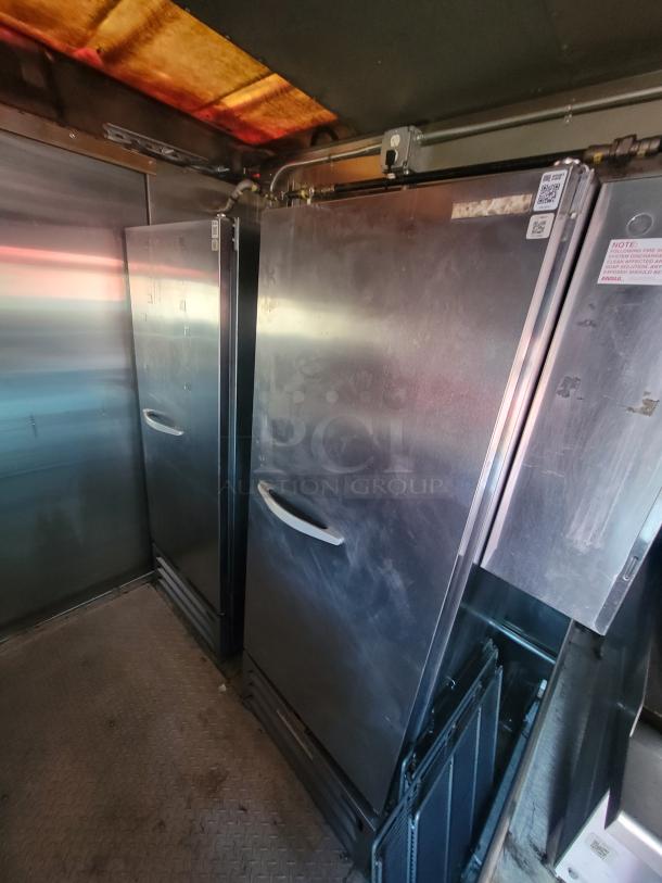 Interior of a 2003 Workhorse Diesel Food Truck with commercial kitchen, featuring stainless steel equipment and refrigeration units.