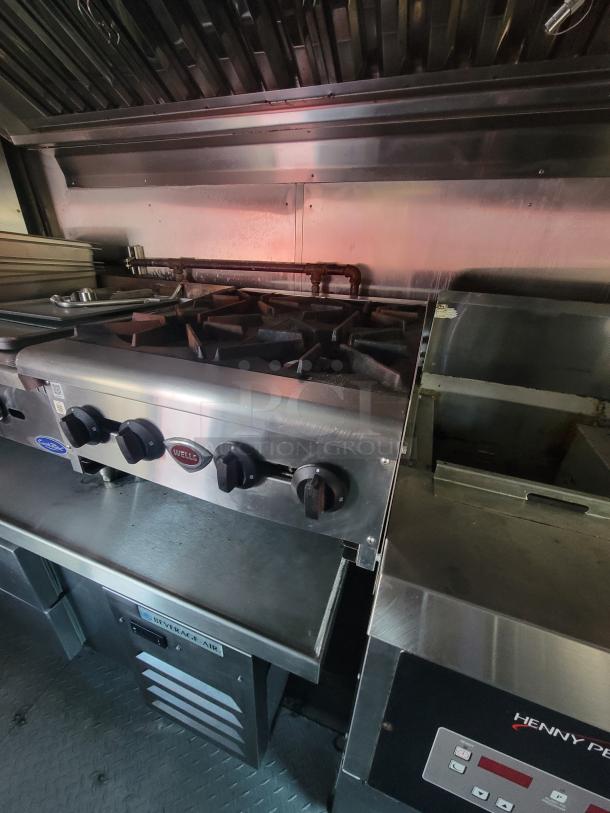 2003 Chevrolet P24 food truck interior with Wells commercial stove, Henny Penny fryer, Beverage Air fridge. Turnkey-ready condition.