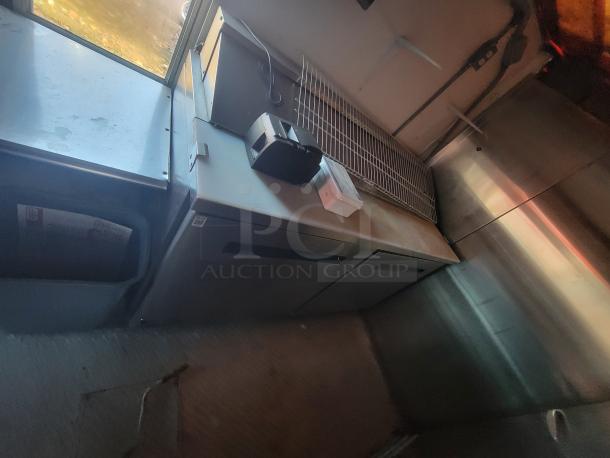Interior view of 2003 Workhorse Diesel Food Truck, featuring stainless steel counters, shelving, and commercial kitchen setup.