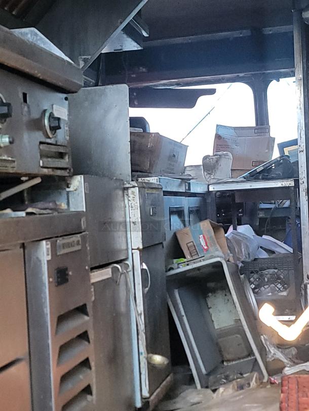 1973 International Step Van with fire-damaged commercial kitchen equipment, featuring stainless steel appliances needing repair.