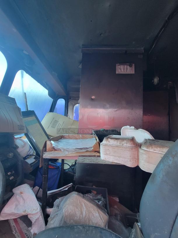 1973 International Step Van interior with fire-damaged commercial kitchen equipment. Visible smoke damage. Needs restoration.