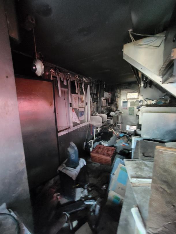 1973 International Step Van with fire-damaged commercial kitchen equipment. Includes stainless steel units, smoke damage visible.