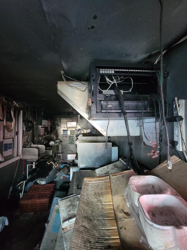 1973 International Step Van interior with fire-damaged commercial kitchen equipment. Features stainless steel fixtures. Ideal for salvage.