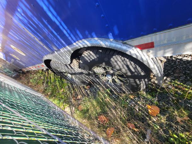 2021 Quality 24' trailer wheel and partial metallic body detail, reflecting manufacturing quality and condition.