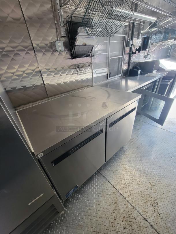2021 24' Quality Trailer with high-capacity electric kitchen, stainless steel surfaces, commercial appliances, and metal flooring.