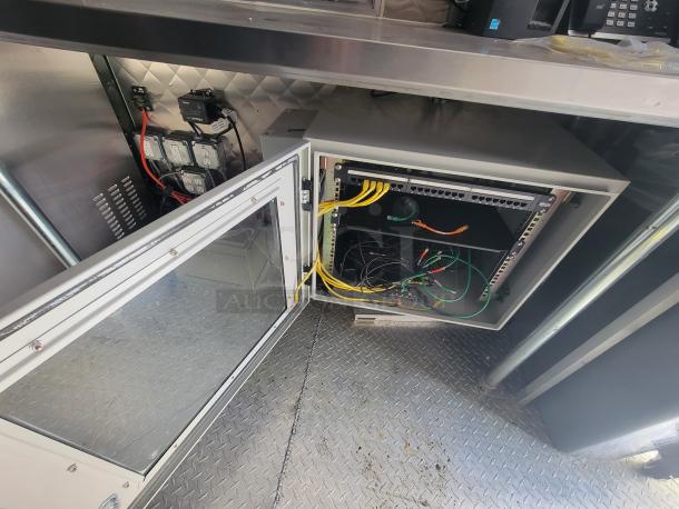 2021 Quality Trailer interior featuring an open electrical panel with cables and switches for high-capacity electric kitchen equipment.