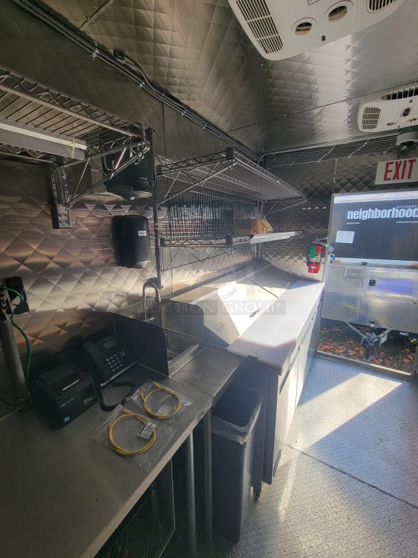 2021 24' Quality Trailer with high-capacity electric kitchen, featuring stainless steel counters, shelving, and commercial appliances.