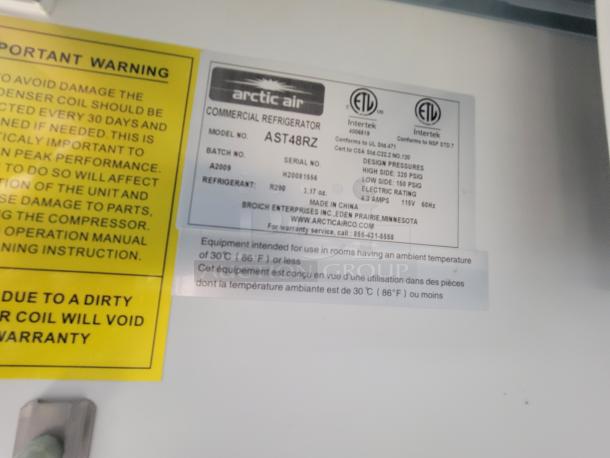 Arctic Air commercial refrigerator label, Model AST48RZ, with technical and warranty details in a Quality trailer kitchen.