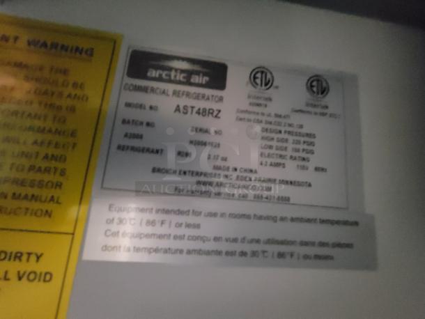 Label showing Arctic Air commercial refrigerator model AST48RZ specifications and safety warnings.