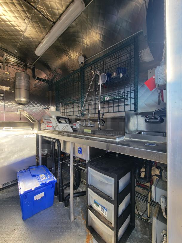 16' Quality commercial food trailer with stainless steel interior, sink, storage drawers, and shelving. Pristine condition.