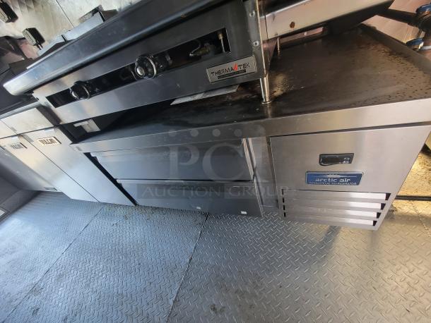 High-end 2021 16' commercial food trailer interior with Vulcan stove and Arctic Air fridge. Excellent condition.