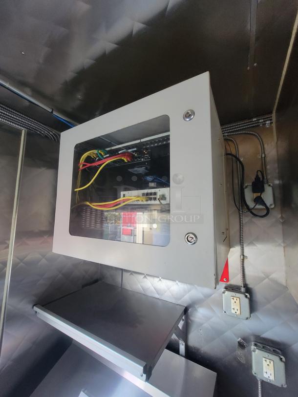 Interior view of a Quality 16' commercial food trailer, showing an electrical panel setup with wiring and outlets.
