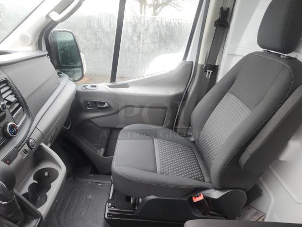 Interior of a 2020 Ford Transit 350 Cargo Van showing the passenger seat, dashboard controls, and storage compartments.