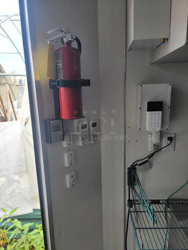 Interior view of 2021 SDG food concession trailer showing a mounted fire extinguisher, control panel, and electrical outlets.