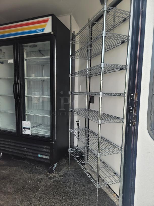 2021 SDG 20' concession trailer interior with commercial refrigerator and metal shelving, ready for high-volume sales.