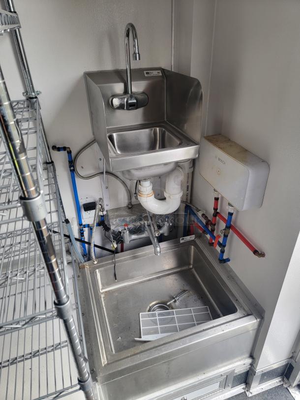 Stainless steel sink and plumbing in a 2021 SDG 8.5' x 20' Merchandising Trailer, equipped for high-volume dessert sales.