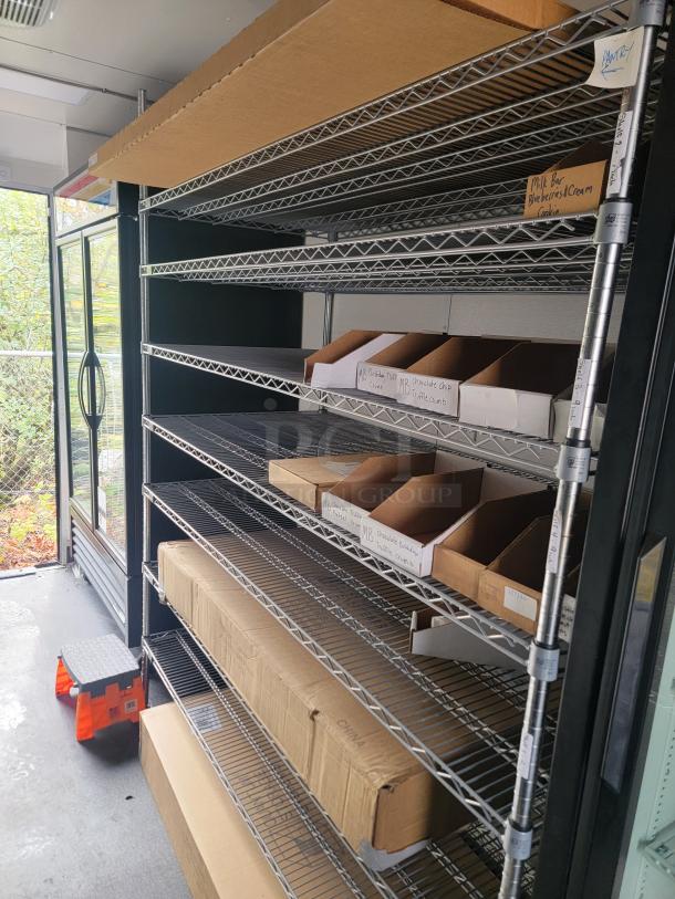 Modern 2021 SDG 8.5' x 20' food concession trailer interior, metal shelves with labeled storage boxes, ready for merchandise.