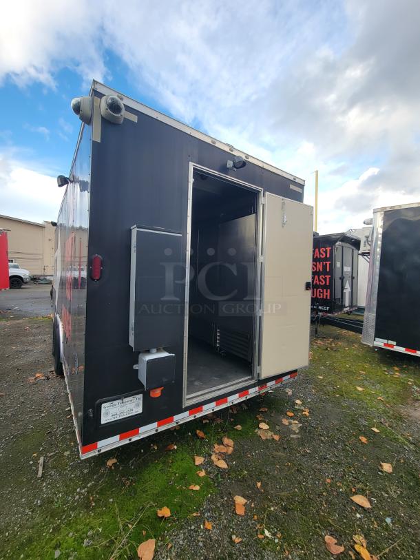 2021 24' Diamond Cargo mobile kitchen trailer, black exterior, partially open rear door showing interior.