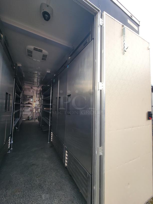 2021 24' Diamond Cargo mobile kitchen trailer interior, showing stainless steel walls, refrigeration units, and shelving.