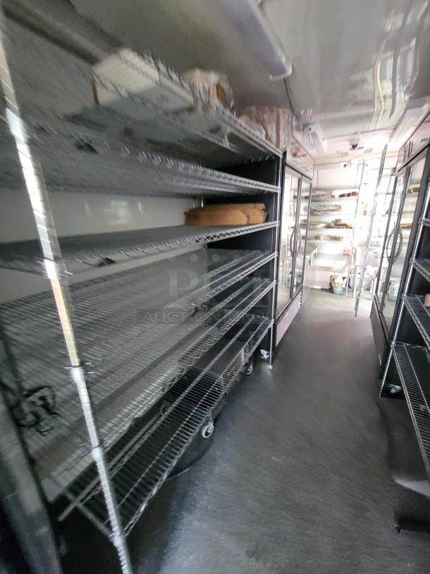 2021 Diamond 24' mobile kitchen trailer interior with stainless steel shelving, True refrigeration units, and durable flooring.
