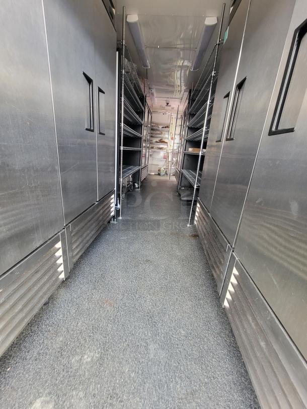 2021 Diamond 24' mobile kitchen trailer interior with stainless steel prep counters and shelving.