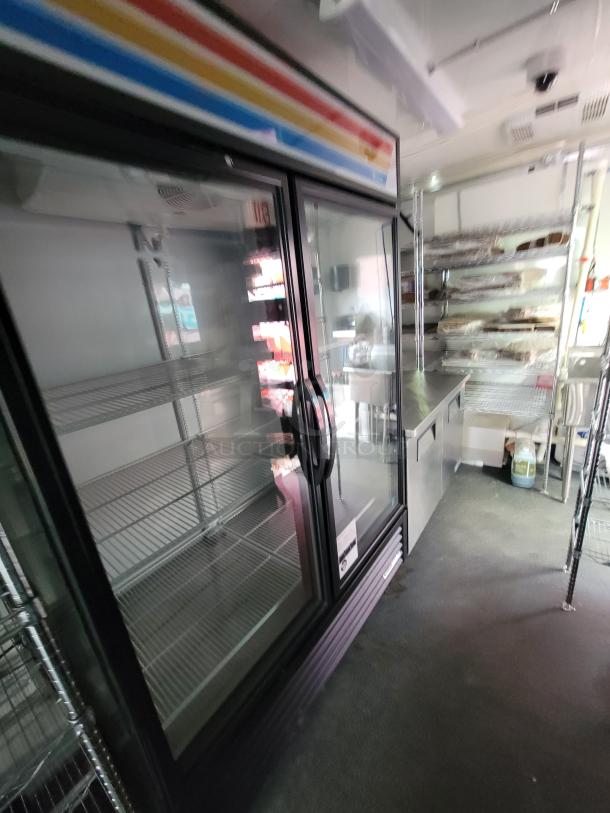 2021 Diamond Cargo 24' mobile kitchen interior with True Refrigeration units, stainless steel prep counters, and shelving.