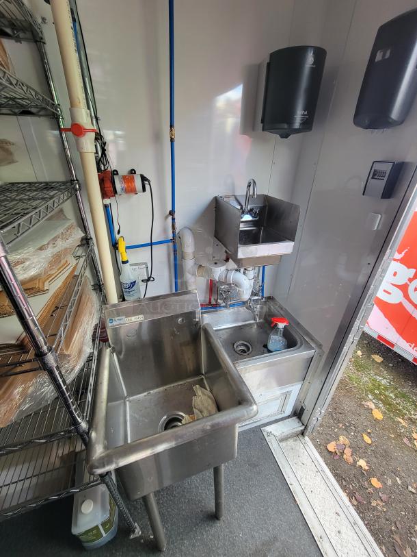 2021 Diamond Cargo mobile kitchen interior with stainless steel sinks, plumbing, and shelving, ideal for high-volume use.