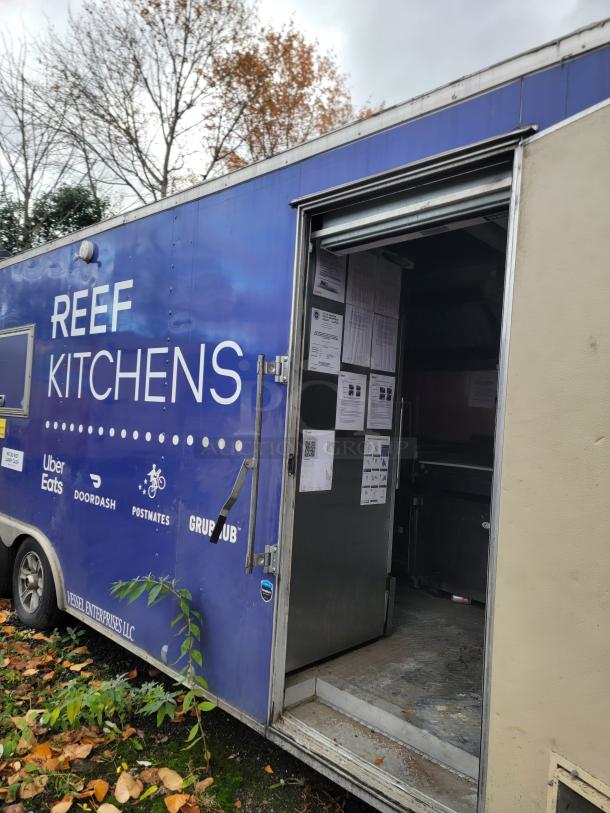 2019 Rock Solid 24' commercial food trailer, branded REEF Kitchens, external view with open door.
