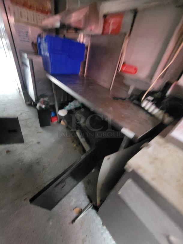 2019 Rock Solid 24' Food Trailer interior view, featuring a commercial kitchen workspace with storage shelves and equipment.