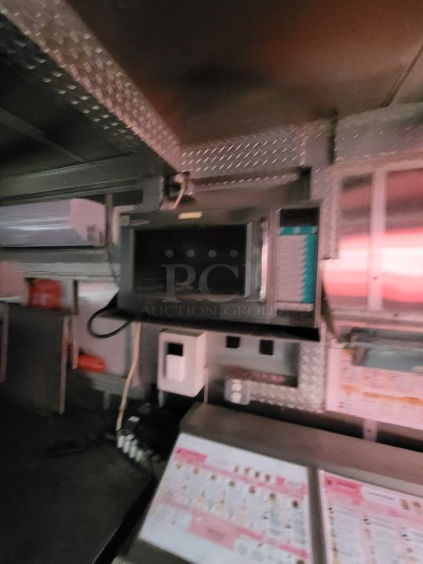 Interior view of a 2019 Rock Solid Cargo 24' food trailer featuring cooking and refrigeration equipment.