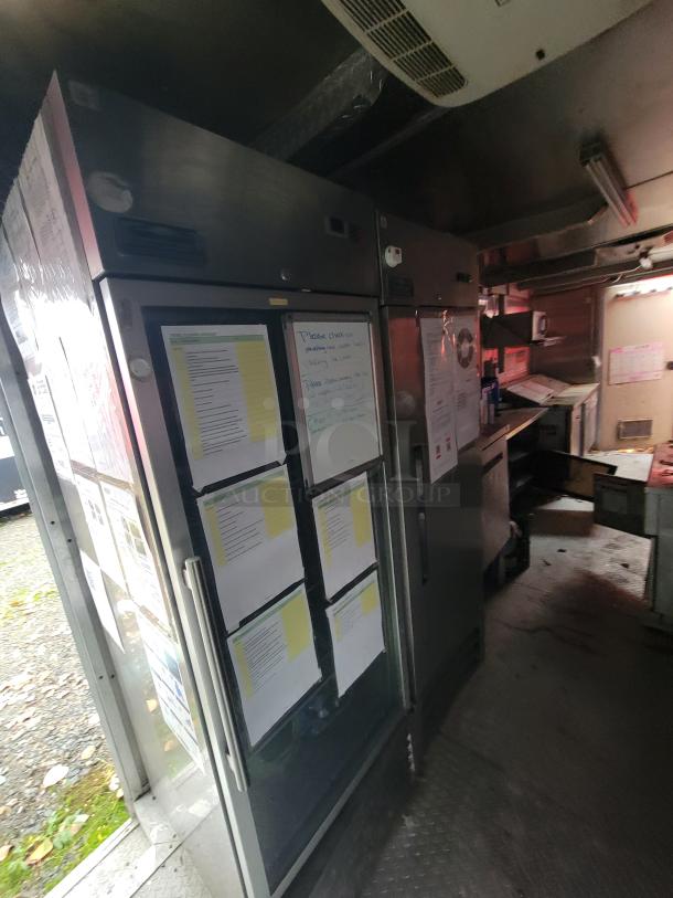 2019 Rock Solid Cargo 24' commercial food trailer interior, featuring Arctic Air refrigerator and freezer units with visible notes on doors.