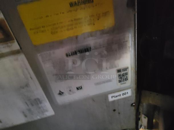 Blurred image of identification labels and warning stickers on a commercial food trailer's interior panel.