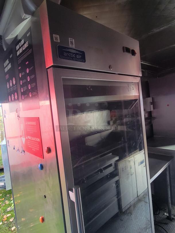 Arctic Air commercial refrigerator inside a 2021 16-foot Quality Food Trailers kitchen vessel. Tags and labels visible.