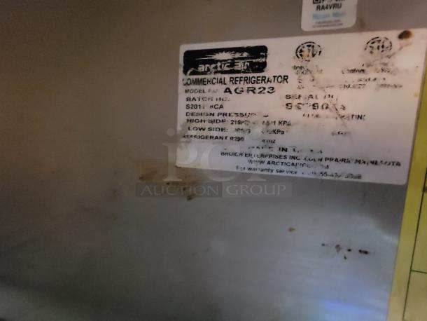 Label indicating a commercial refrigerator by Arctic Air, model AGR23. Shows pressure details and refrigerant type.