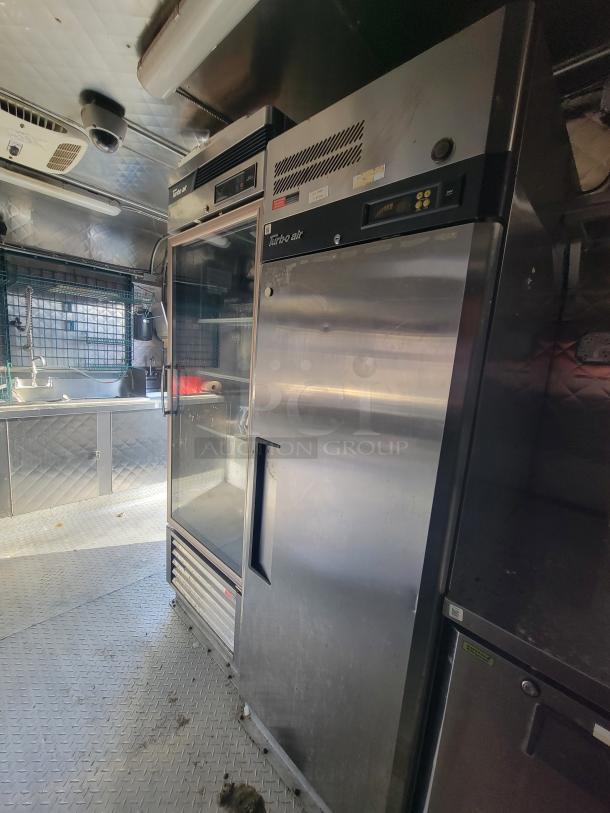 24' food trailer interior with stainless steel Turbo Air appliances, diamond plate flooring, and ceiling vents, ready for business.