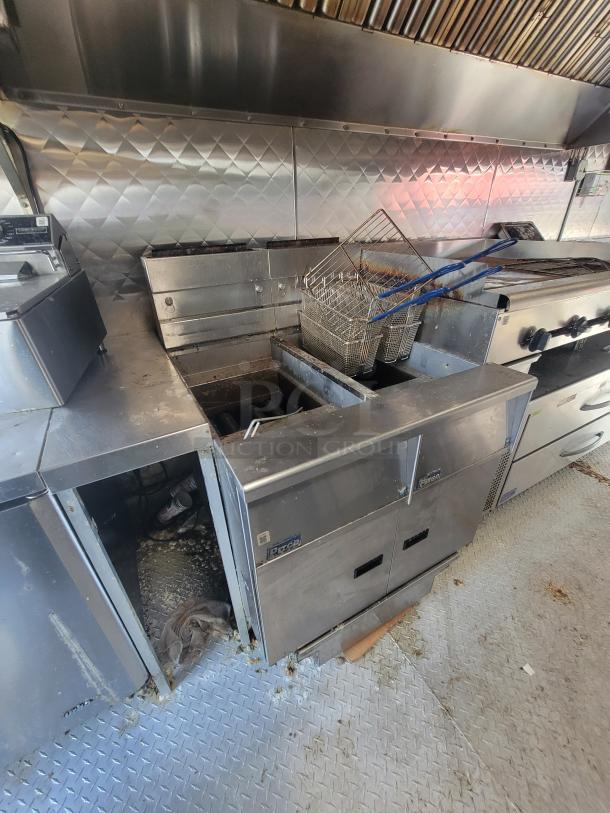 Professional-grade food trailer kitchen interior with stainless steel equipment, fryers, and a commercial range. Ready for use.
