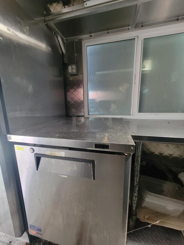 Interior of 2020 Quality 24' food trailer, featuring stainless steel counter, professional-grade equipment, and electric outlets.