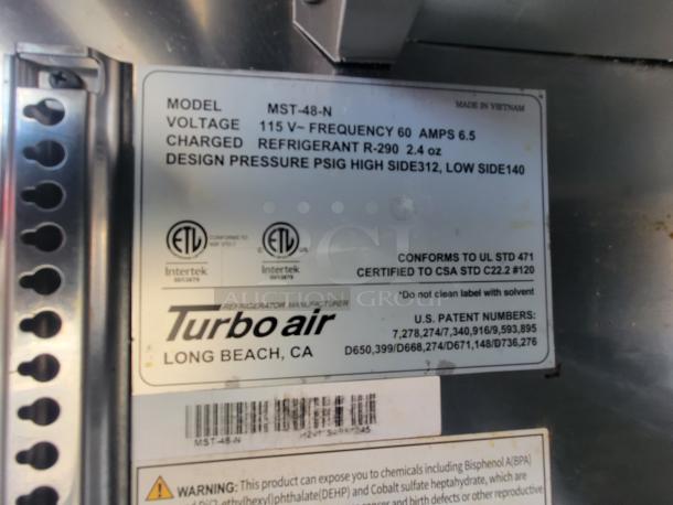 Label on Turbo Air MST-48-N refrigerator, showing voltage, refrigerant details, and compliance standards.
