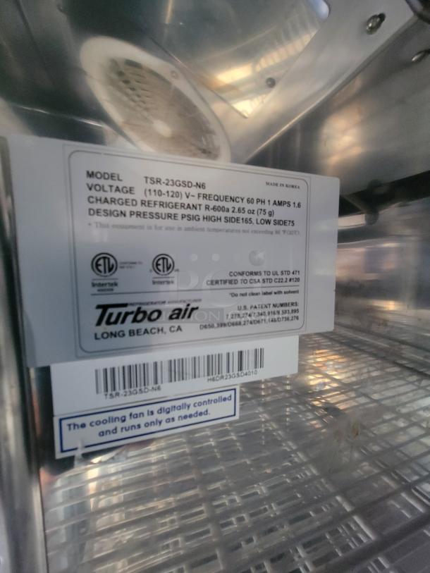 Turbo air model TSR-23GSD-N6 label in food trailer. Indicates 110-120V, 60Hz, R-600a refrigerant. Cooling fan is digitally controlled.