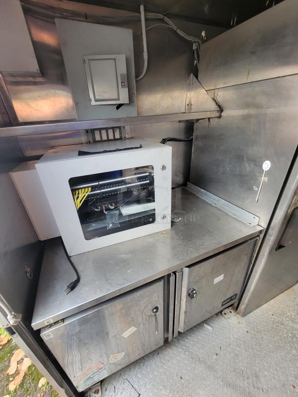 2019 Quality 24' food concession trailer interior, featuring stainless steel prep tables and storage units, excellent condition.
