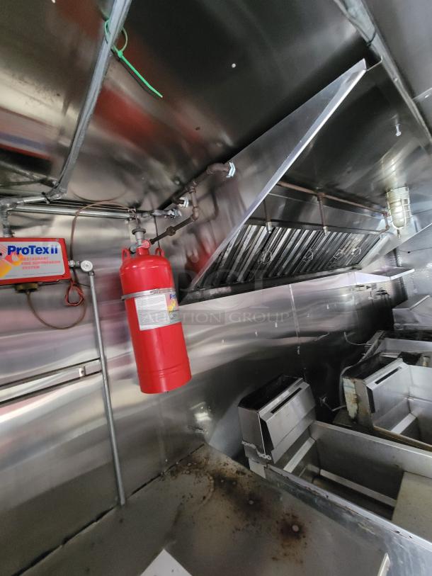 2019 Quality 24' food concession trailer interior with ProTex II fire suppression, stainless steel surfaces, and gas range.