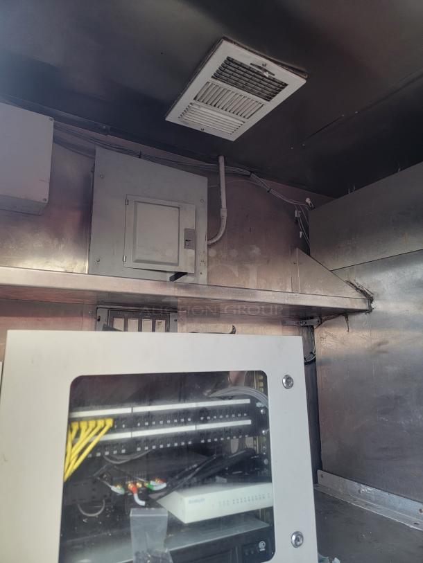 Interior of 2019 Quality 24' food concession trailer, showcasing electrical panel and ventilation system. Clean, well-maintained.