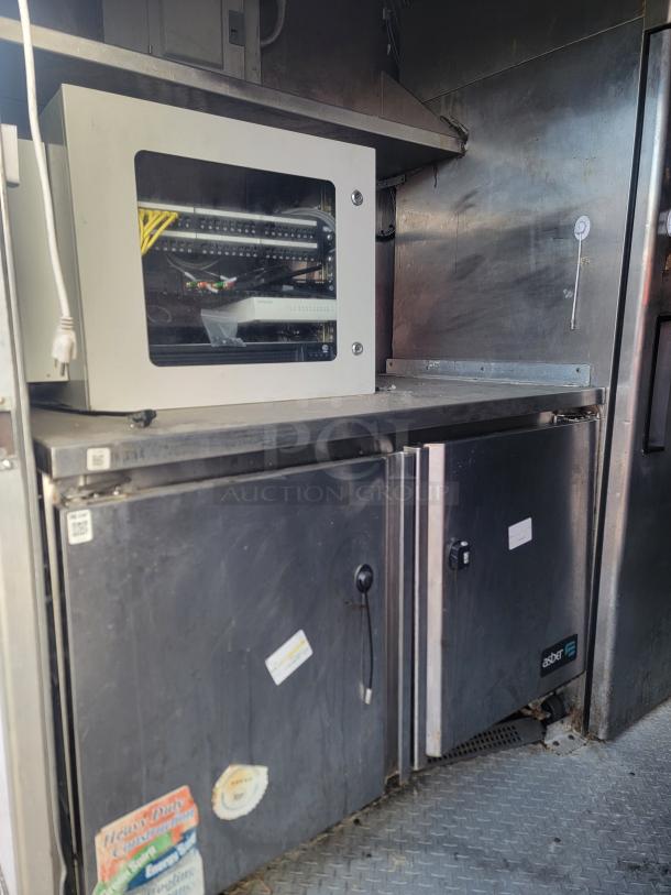 2019 24' food concession trailer interior with stainless steel refrigerators, commercial equipment, and visible wiring.