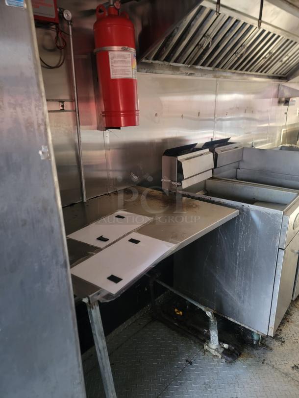 2019 Quality 24' food concession trailer interior, featuring a Royal gas range, stainless steel prep table, and ProTex II fire extinguisher.