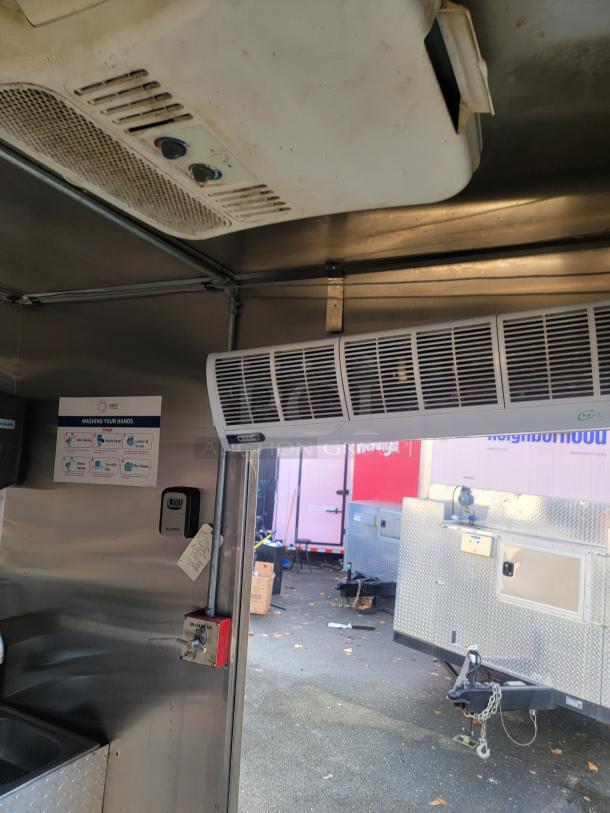 Interior view of a 2019 Quality 24' food concession trailer, showing stainless steel fixtures, air conditioning, and compliance signage.