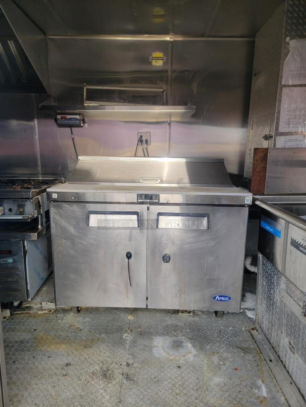2019 Quality 24' food concession trailer interior with commercial prep tables and stainless steel equipment, fully equipped.